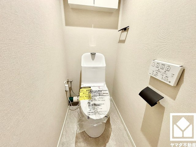 明るく清潔感溢れるトイレです。温水洗浄便座付きで、季節を問わずいつでも温かい便座をお使いいただけます。トイレットペーパーのストックや消耗品置き場などとしてお使いいただける吊戸棚がございます。