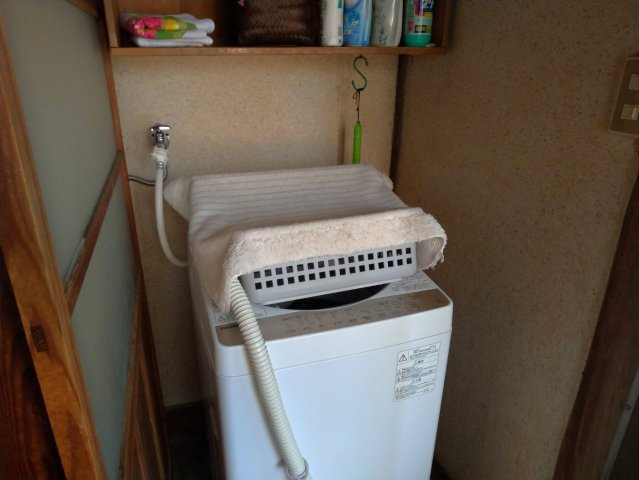 室内に設けられた洗濯機置場で、天候を気にせず洗濯ができる便利なスペースです。上部には棚があり、洗剤やタオルなどの収納にも困りません。動線も良く、日々の家事を効率よくこなせる配置となっています。