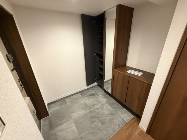 グレー調の床面と深い木目調の建具が調和した、スタイリッシュな佇まい。