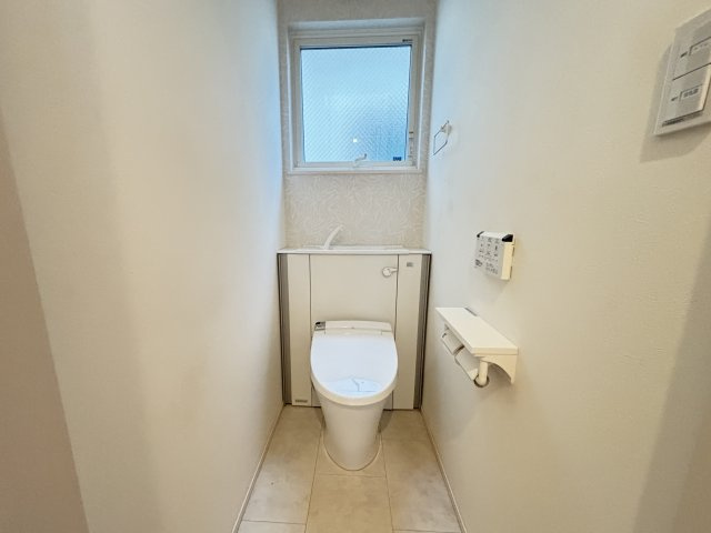 清潔感あふれるトイレ空間です。窓が設けられているため自然換気が可能で、明るく快適な環境を保ちやすくなっています。奥行きある設計で圧迫感が少なく、ゆとりを感じられる空間です。温水洗浄便座を備えています。