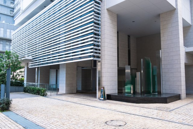 【コーチエントランス外観】アルミルーバー、積層ガラスと金属のオブジェなどで、都心の先進性を表現！