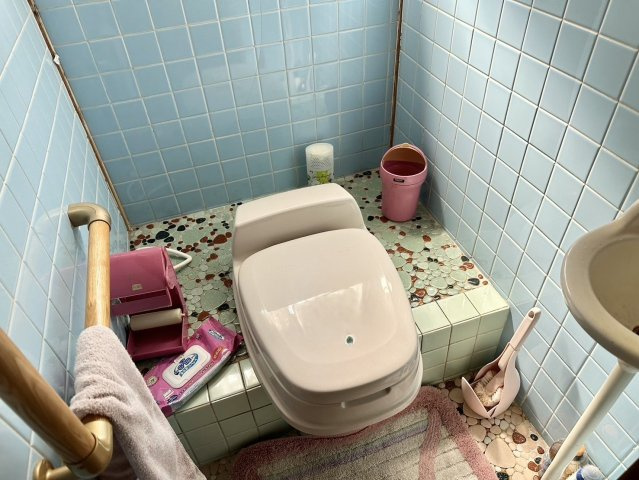 シンプルな造りでタイル張りなので掃除のしやすいトイレです。手すりもついているので、お年寄りの方の転倒防止にも役立ちます。手洗い場がついているので、すぐ手が洗えて清潔に保てますね。