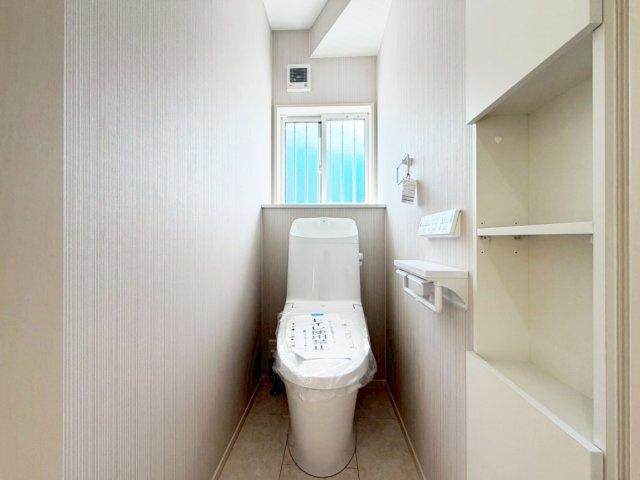 【1号棟　1Fトイレ】壁埋込収納付きで、トイレットペーパーやお掃除用品の置き場所確保。扉も付いているため衛生的です。