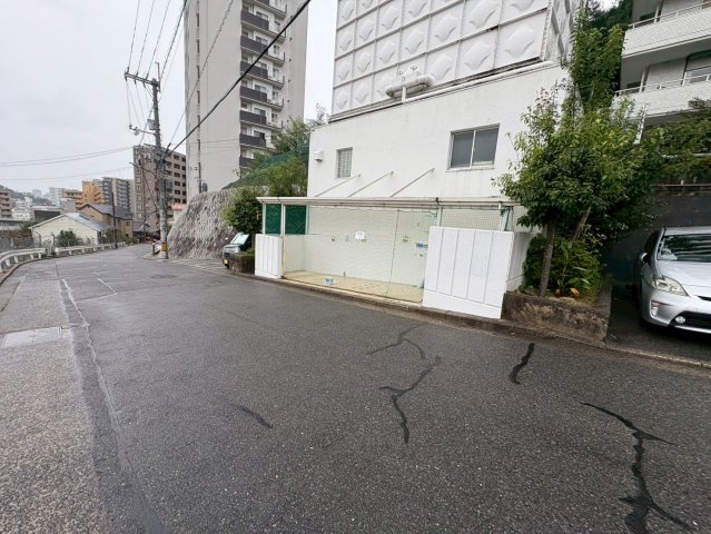 車通りが落ち着いた道路に面しており、道路幅もあるため、安心して出入りできる立地です。歩道やごみ集積所が整備され、日常生活の利便性にも優れています。周囲には緑が多く、落ち着いた雰囲気の住宅街です。