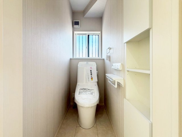 【1号棟　1Fトイレ】壁埋込収納付きで、トイレットペーパーやお掃除用品の置き場所確保。扉も付いているため衛生的です。