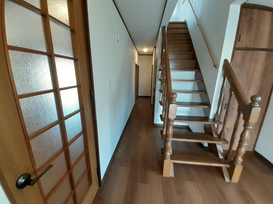 1階玄関から入った廊下部分です。階段の右と階段下が収納部分になっております。左側がリビングへと繋がります。