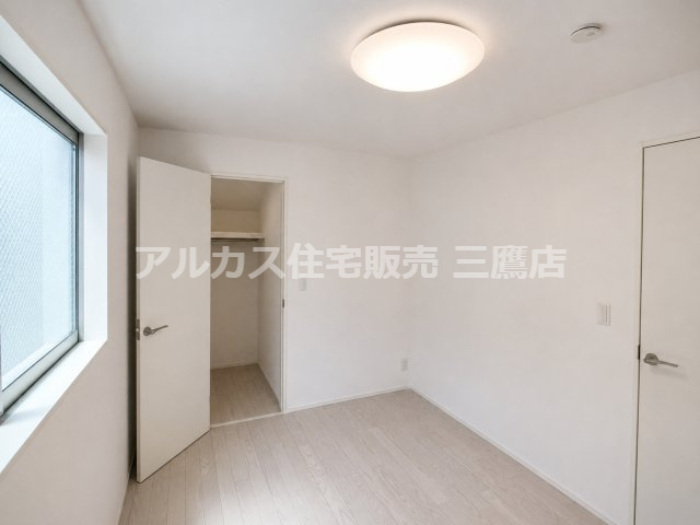 クローゼットと大きな窓を備えた洋室。白を基調とした内装が、すっきりとした印象です。