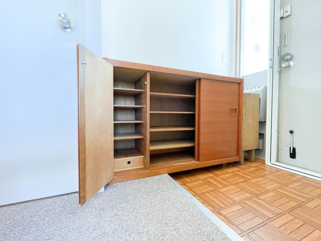 木製の靴箱が設置されている玄関はどこか懐かしさを感じる温かみある空間です。外観や建物全体の雰囲気と調和されており、素敵な物件です。