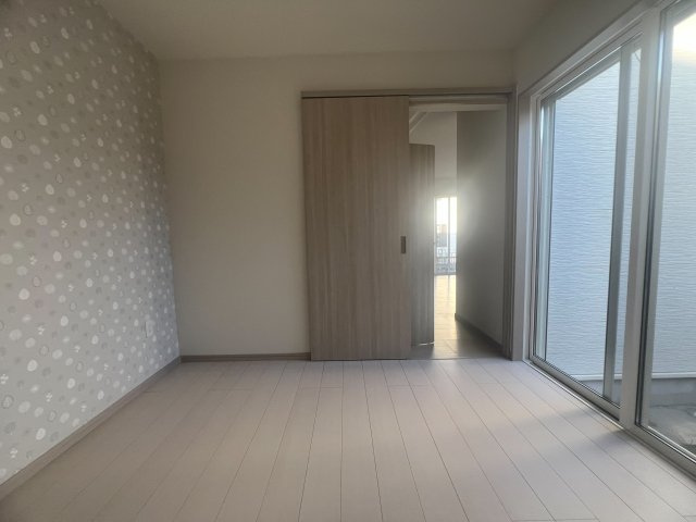アクセントクロスと引き戸を設置した明るい洋室