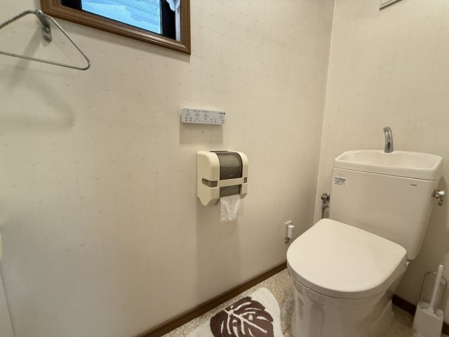 清潔感のある明るいトイレ空間。手洗い付きタンクで使い勝手が良く、節水にも配慮されています。小窓が設けられているため換気もスムーズでいつでも快適に保てます。落ち着いた内装で心地よさを感じられる空間です。