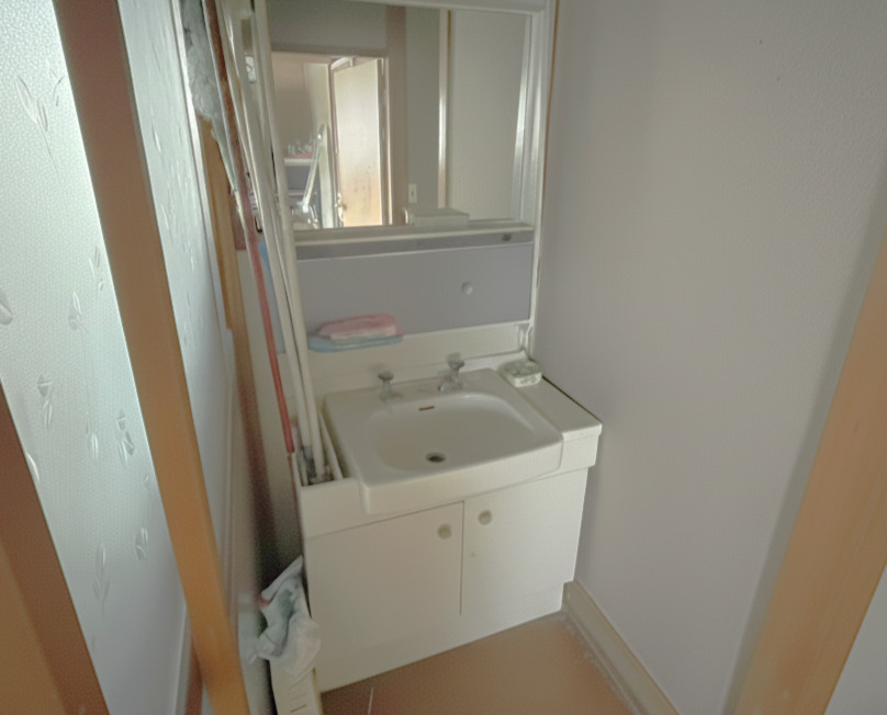 コンパクトな洗面スペースで、鏡付きの洗面台が備わっています。壁や床を明るい素材に替えることで清潔感が増し、限られたスペースでもすっきりとした印象になります。動線上にあるため利便性が高い洗面台です。