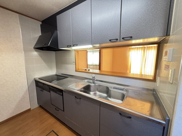 落ち着いたカラーで統一されたシステムキッチンは収納が豊富で調理道具や食器をすっきり整理できます。広めの作業スペースとIHクッキングヒーターで毎日の料理も効率的。リビングが見える開口部付きです。