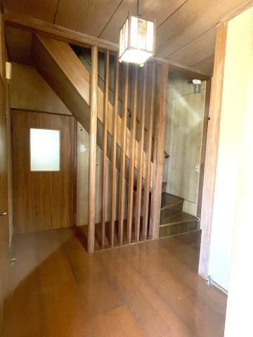 木製の格子壁を配置した廊下。階段横に照明があり、光が届きます