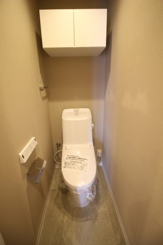 トイレには温水洗浄便座付き！こちらにも吊戸棚が設置されています
