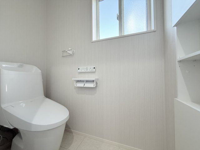 2号棟　トイレ　フチレス形状やお掃除リフトアップ、パワーストリーム洗浄などお手入れのしやすさが特徴。壁には埋め込み型の収納がついています。