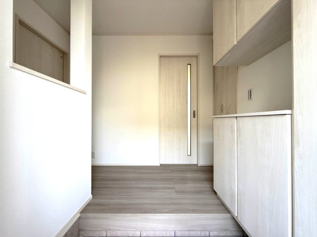 2号棟　玄関　清潔感のある明るい空間が、住まう人や訪れる人を心地良く迎え入れてくれます。約60足収納できるシューズボックスがあります。