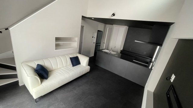 無駄を省いたシンプルなデザインが魅力のリビング空間。モノトーンでまとめた内装が上品で落ち着いた印象を与えます。フラットなアイランドキッチンと一体感のあるレイアウトで、すっきりとした暮らしを実現。