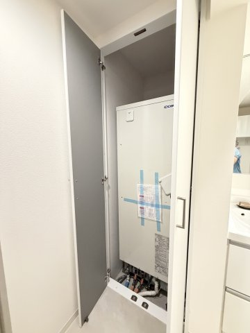 【電気温水器】　扉付きの専用スペースに電気温水器が設置され、室内にすっきりと収まっています。
