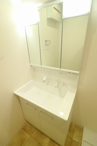 シャワー付き洗面化粧台を採用し、朝の身支度もスムーズ。三面鏡裏収納付きで小物類もすっきり整理でき、清潔感のある快適な洗面空間を実現しています。