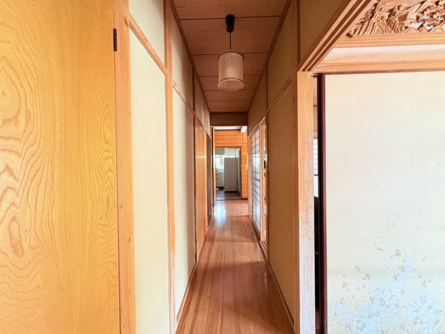 木の風合いを感じられる落ち着いた空間。和室をはじめ複数の居室へアクセスでき、部屋数の多い住まいをスムーズにつなぐ動線。奥まで視線が抜けるため圧迫感が少なく、昔ながらの日本家屋らしい趣も魅力です。