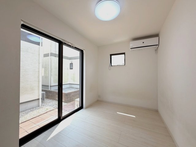 「大きな掃き出し窓から自然光が心地よく差し込む洋室。明るい木目調のフローリングとホワイトのクロスが、お部屋をより広々と爽やかな印象に見せてくれます。」
