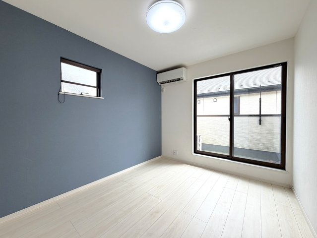 落ち着きのあるブルーグレーのアクセントクロスが、お部屋に洗練された印象を与えます。明るい木目のフローリングとのコントラストが美しく、北欧風やモダンなインテリアとの相性も◎