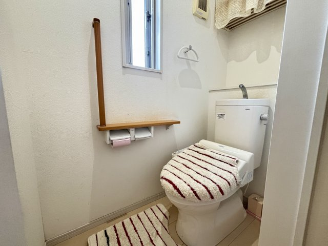 2階のトイレは明るい採光窓付きで自然光が入り換気もスムーズ。木目調の手すりが設けられ、安全性にも配慮されています。上部には棚スペースがありトイレットペーパーやタオルの収納にも便利にお使いいただけます。