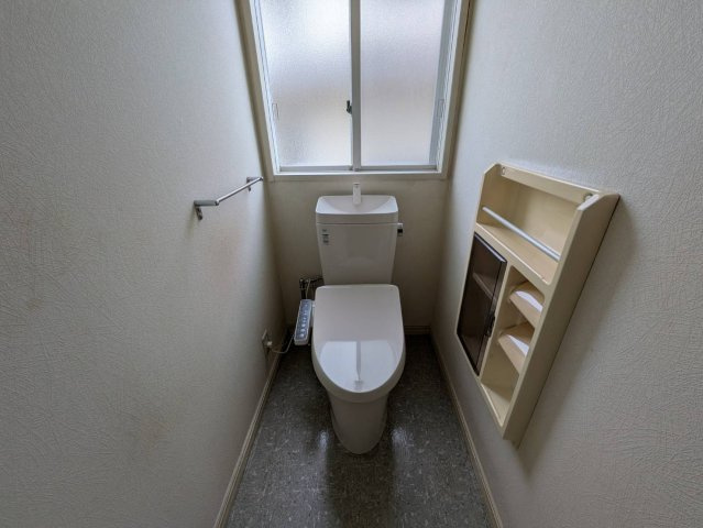 窓付きで明るく、しっかり換気ができる清潔感のある快適なトイレです。温水洗浄便座付きで機能性も充実。便座は新品へ交換予定。壁面収納もあり、トイレットペーパーや小物の整理にも便利な使い勝手の良い空間です。