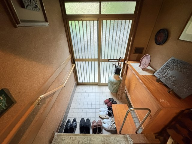 引き戸タイプの玄関で、やわらかな光を取り込む落ち着いた空間。上がり框は腰掛けやすい高さで、靴の脱ぎ履きもスムーズ。下足収納も備わっており、玄関まわりをすっきり保てるのも魅力。和の趣を感じられます。