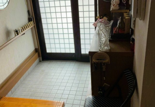 採光を確保する障子風の引き戸と、靴箱が備わる明るい玄関。