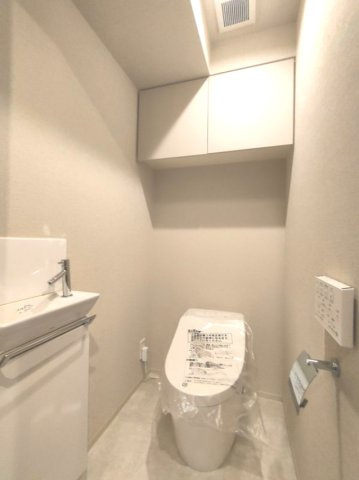 【トイレ】　洗浄機能付きトイレ。上部には収納付で、トイレットペーパー等、買い置きもしやすそうです。