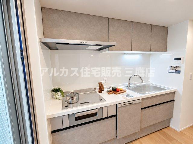 上下にたっぷりと収納を備えたシステムキッチン。落ち着いたグレー調のデザインが洗練された印象を与えます。