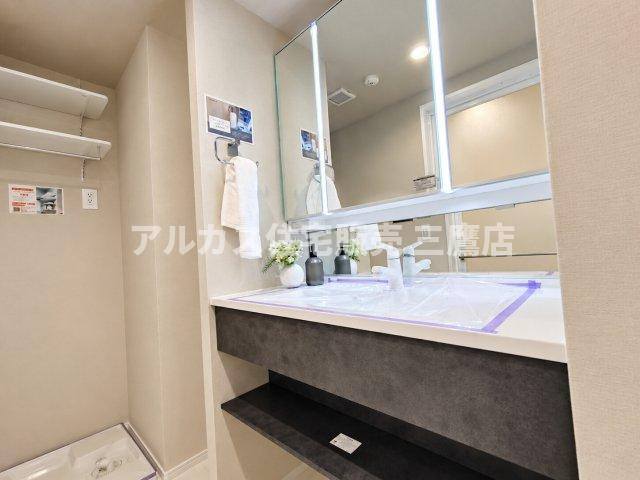 モダンなスタイリングの洗面化粧台と洗濯機置き場のある脱衣スペース。可動棚も備わり、タオルや洗剤などの収納にも便利です。　　　
