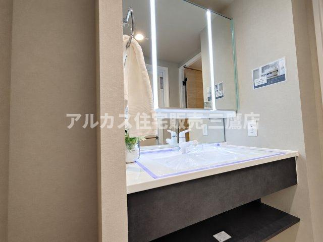 LED照明がついた三面鏡付きの洗面化粧台。鏡裏や下部に収納スペースを備え、洗面用具や小物をスマートに整理整頓できます。