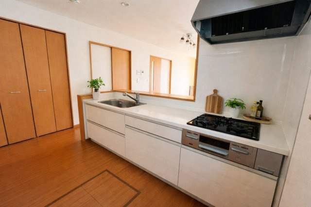 料理をしながら、家族の声が聞こえる。対面キッチンが、暮らしにちょうどいい距離感と、あたたかな時間を運んでくれます（AIによる加工をしています）