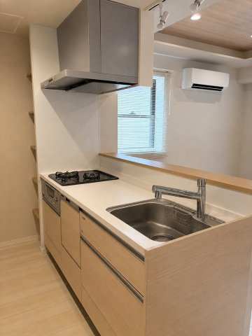手元をさりげなく隠せるカウンター付きの対面型システムキッチン。豊富な収納スペースを備えており、生活感を抑えつつ、リビングの様子を伺いながら手際よくお料理を楽しめる空間です。