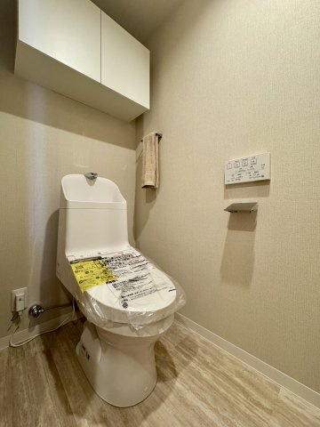 広く清潔感のあるトイレです。上部棚付きで、清掃道具などもすっきり収納できます。