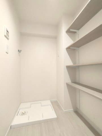 【室内洗濯機置き場】　壁面に棚が造作されています。洗剤のストックやタオルなどを収納できます。