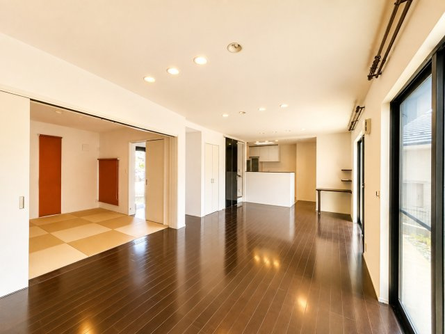 開放感あふれる広々としたLDKは、大きな窓から自然光がたっぷり差し込む明るい空間。ダークトーンの床が上質な雰囲気を演出し、和室とつながることでさらにゆとりある使い方が可能です。