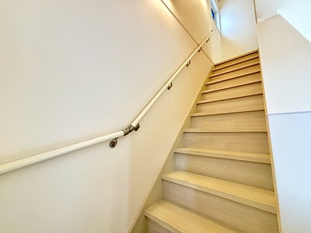 手すり付きで安全性にも配慮された階段です。窓から自然光を取り込めるため、日中は明るく開放的な空間となっています。階段幅にもゆとりがあり、お子様からご年配の方まで安心して昇り降りしやすい設計です。