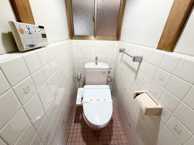 温水洗浄便座付きのトイレ。タンク上部には手洗いがあり、使い勝手にも配慮されています。窓付きで明るさと換気を確保。操作パネルも見やすく、快適にご利用。落ち着いた空間で毎日気持ちよく使える設備。