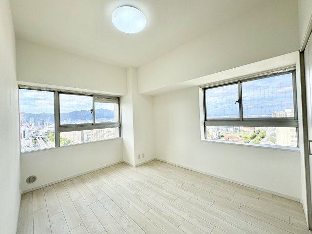 洋室約6．7帖　角部屋のため、2面の窓があり、それぞれ海と六甲山、神戸港が見える神戸らしい眺望があります。