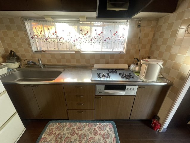 収納豊富なキッチンは、3口コンロでお料理の効率が良好です。　明るい窓付きで換気も可能です。勝手口があるため、ゴミ出しや買い物後の荷物の搬入もスムーズです。使い勝手の良い動線が魅力です。