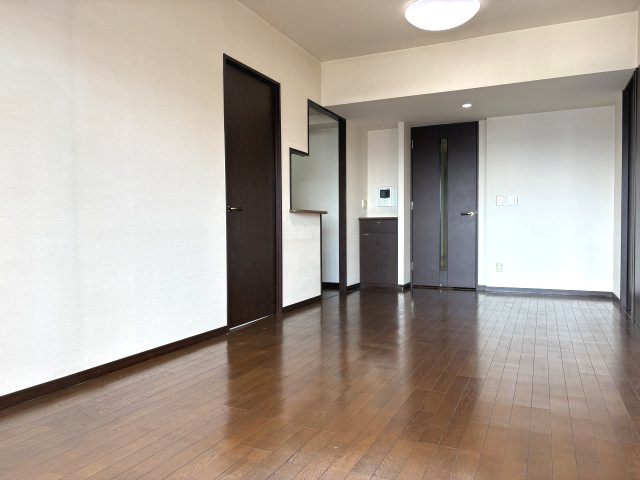 落ち着いたブラウンの建具が映える、品格ある内装。9階南向きにつき、明るいだけでなくプライバシー性も確保されています。隣接する和室を繋げれば、ライフスタイルに合わせた広々空間が実現します。