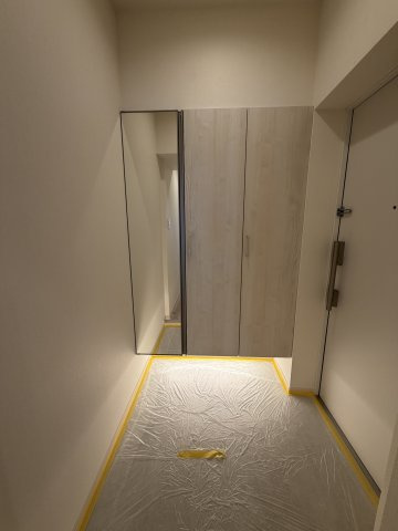 出かけ際の身だしなみチェックに便利な大きな全身鏡を配置。足元を照らす間接照明が、明るく上品な玄関空間を演出します。