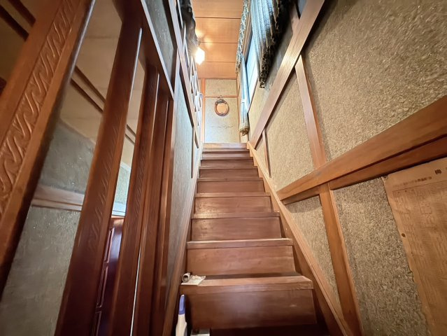 木の温もりを感じる落ち着いた雰囲気の階段スペースです。手すりも設置されており、上り下りの際も安心感があります。窓から自然光が入り、日中は明るさを感じながら移動できる点も魅力。