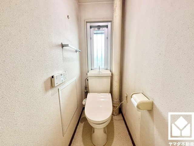小窓付きで明るく清潔感溢れるトイレです。タオル掛けやペーパーホルダーが設置されています。