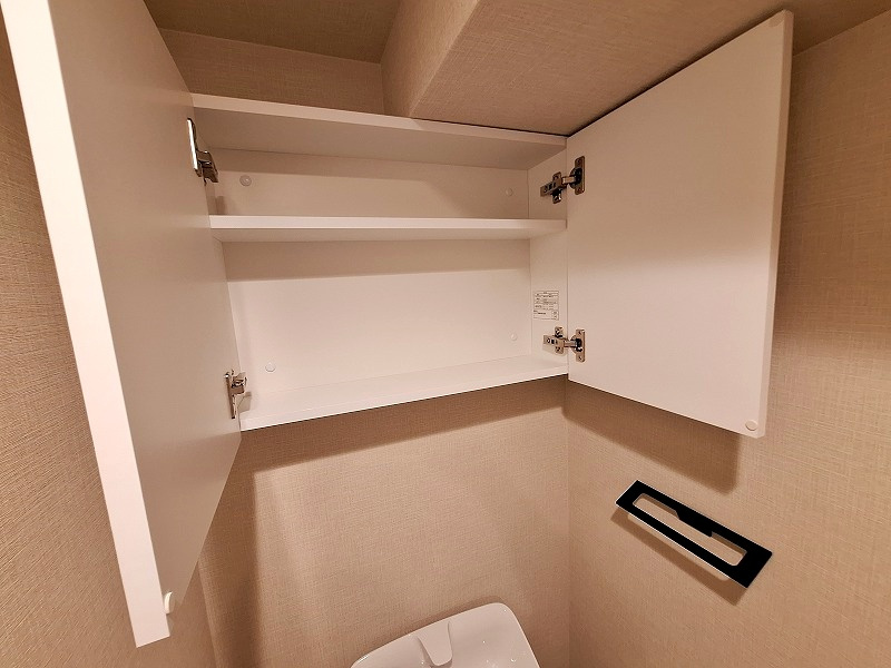 扉を閉めれば中身が見えないスマートなトイレ上部吊戸棚。必要な小物をサッと取り出せる機能性と、空間全体の清潔感を両立させた快適な仕様です。