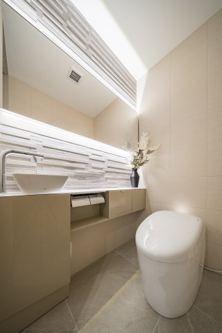 石積み調のアート壁と、美しい手洗い器。細部にまでこだわった、意匠性の高いレストルーム。