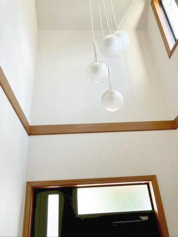 吹抜けの高い位置から光が差し込み、玄関全体を明るい印象に！